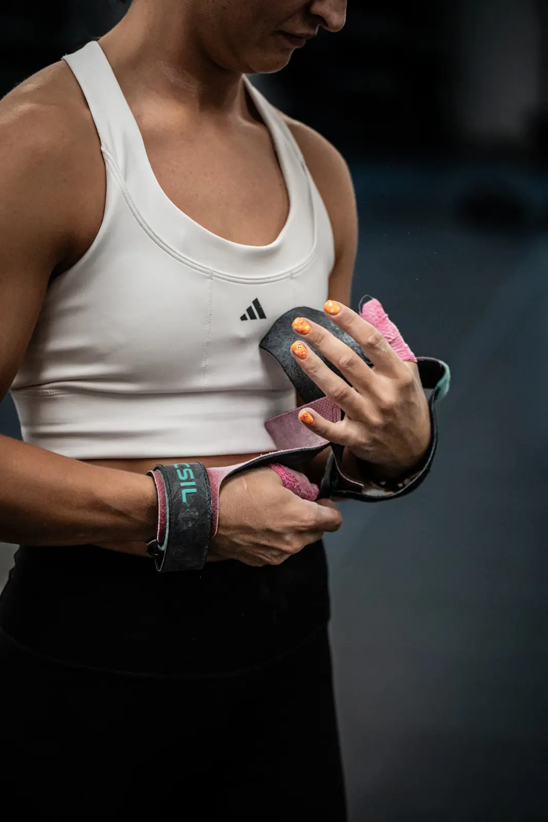 Athlete fastening gymnastics grips before a workout