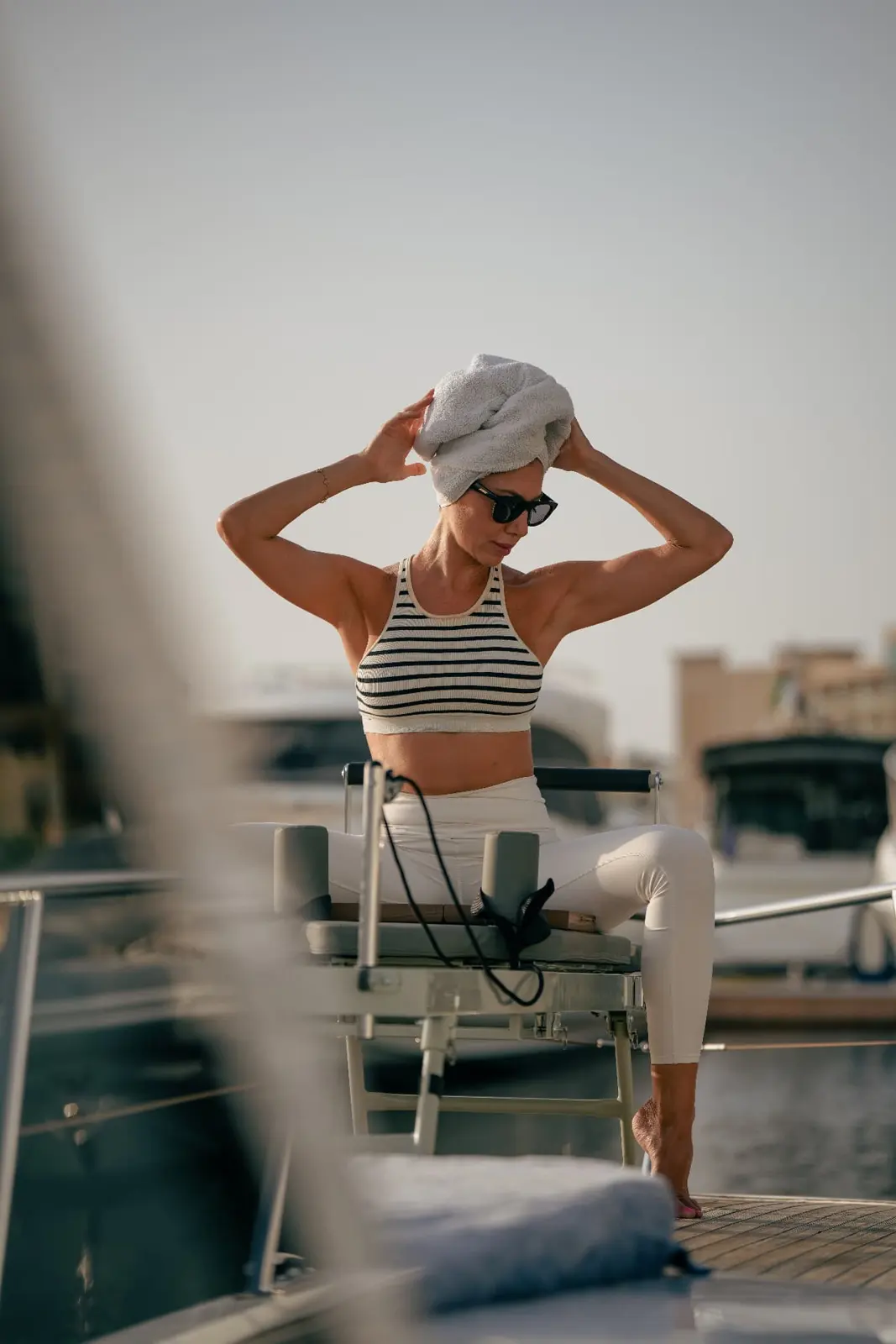 Pilates instructor with hair towel on a yacht deck