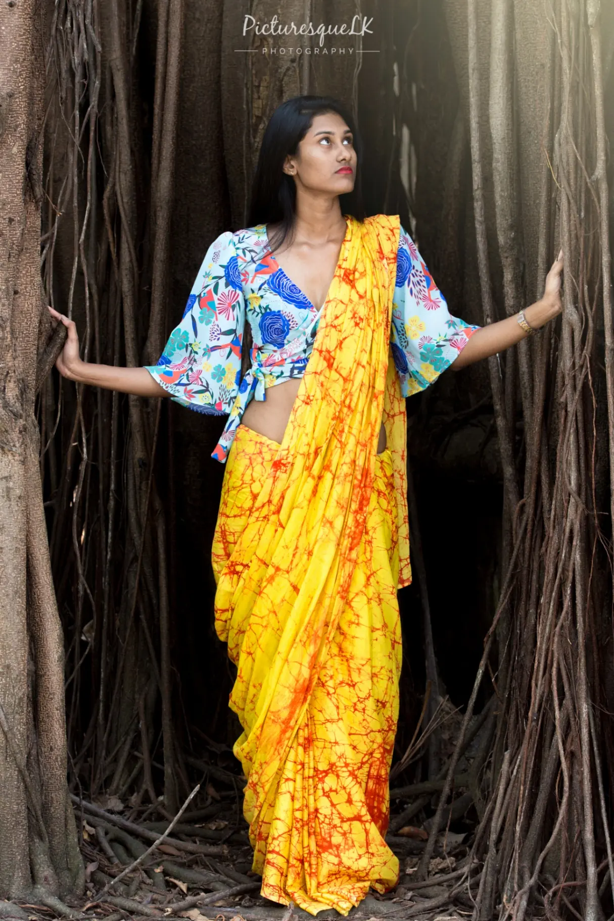 Yellow batik saree portrait between banyan roots