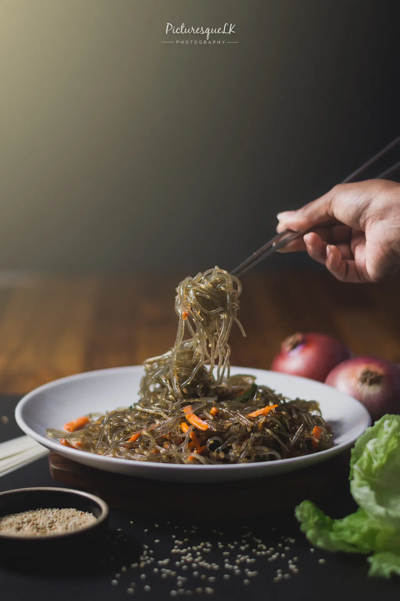 Japchae glass noodles lifted with chopsticks