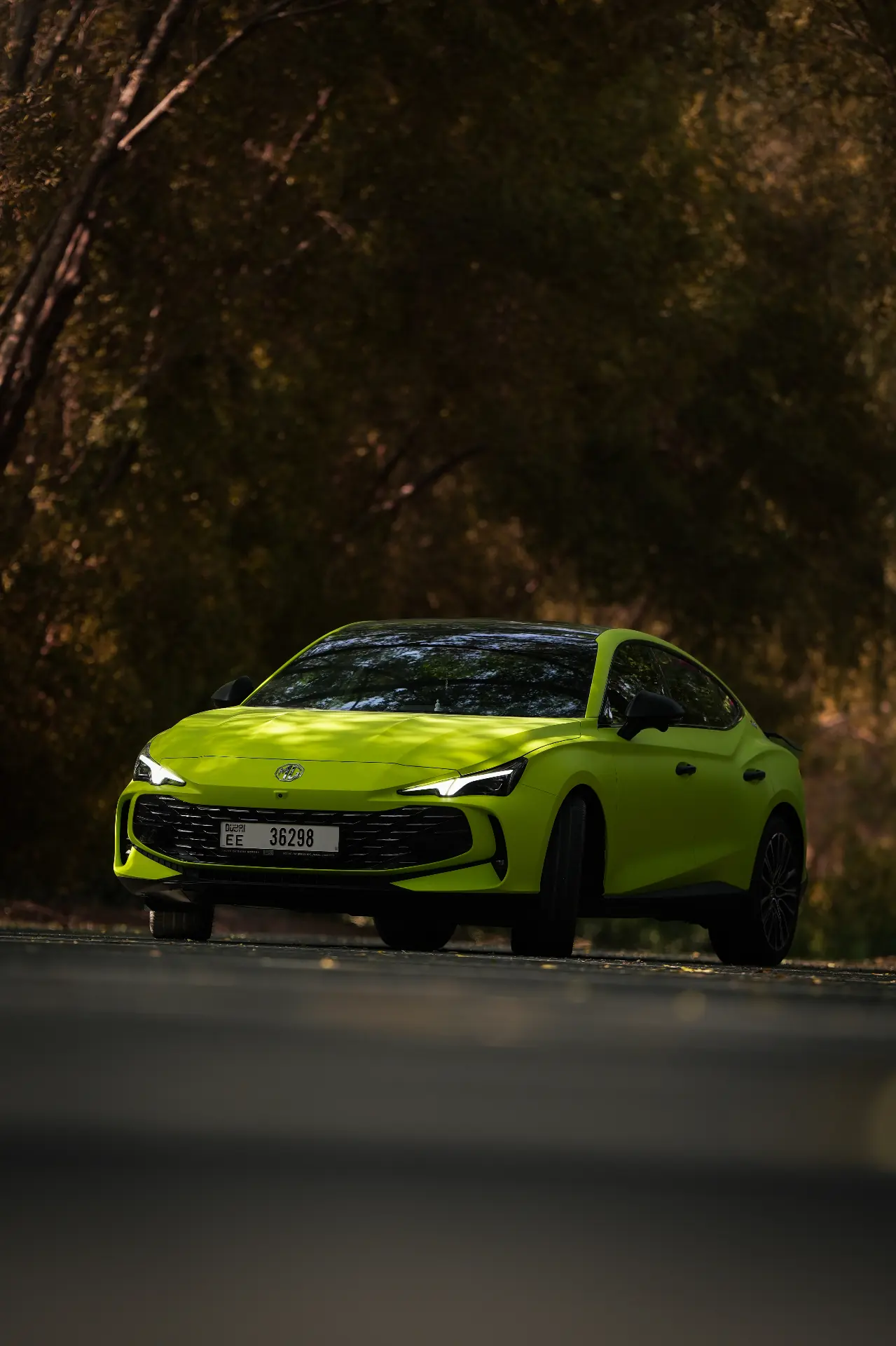 MG neon green sports coupé under Dubai tree canopy