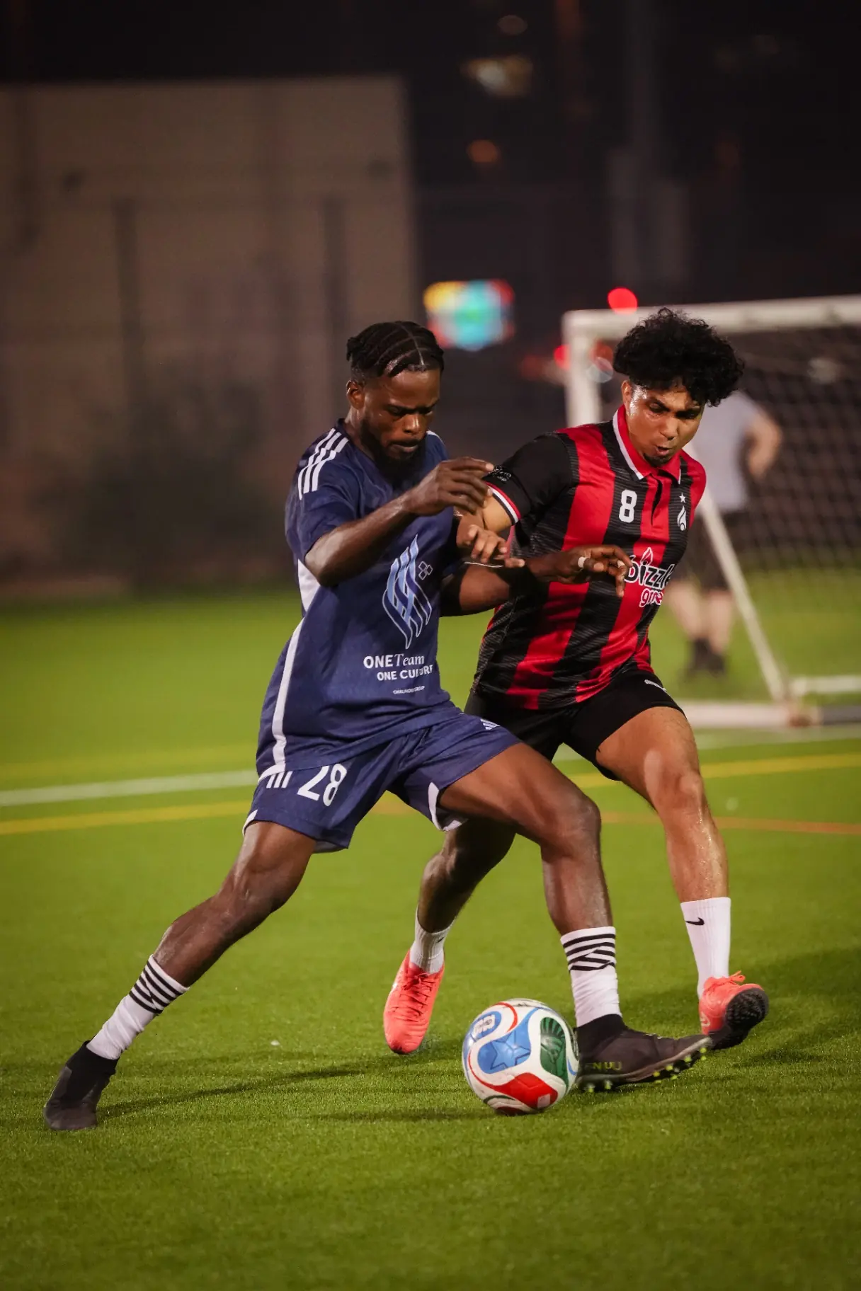 Two players battling for the ball at night